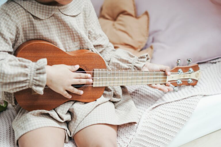 a girl holding brown ukulele
